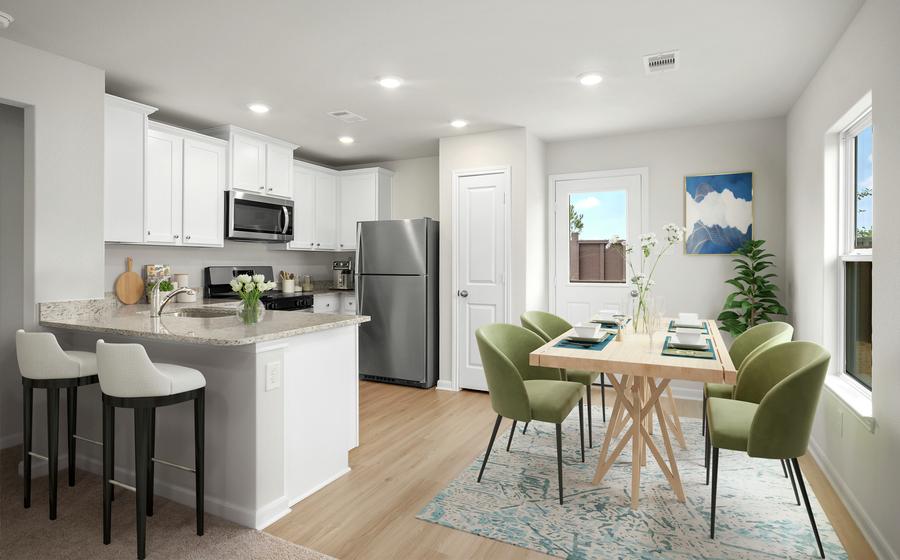 The staged kitchen has beautiful stainless steel appliances and plank flooring.