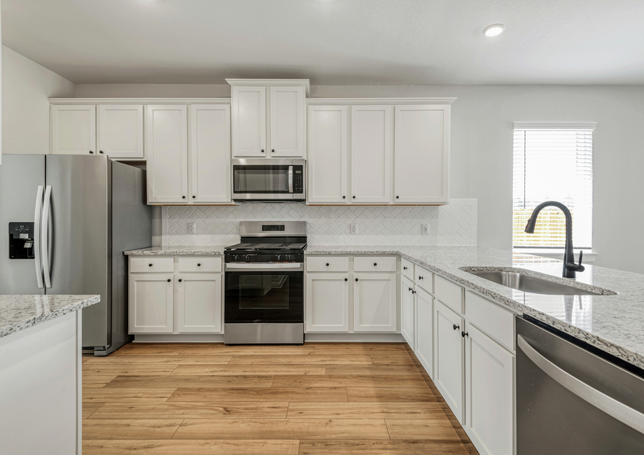 A chef-ready kitchen with granite countertops and beautiful backsplash