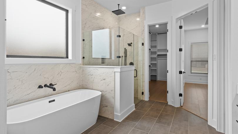 The gorgeous master bathroom has a large glass, walk-in shower and tub.