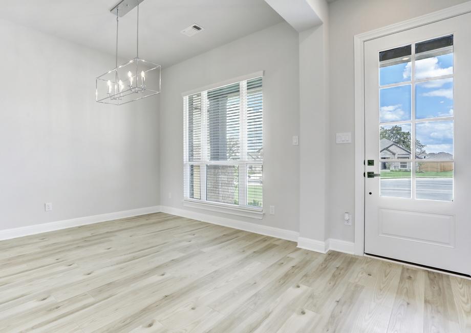 Formal dining room located off of the entry, with large windows and wood-style flooring.