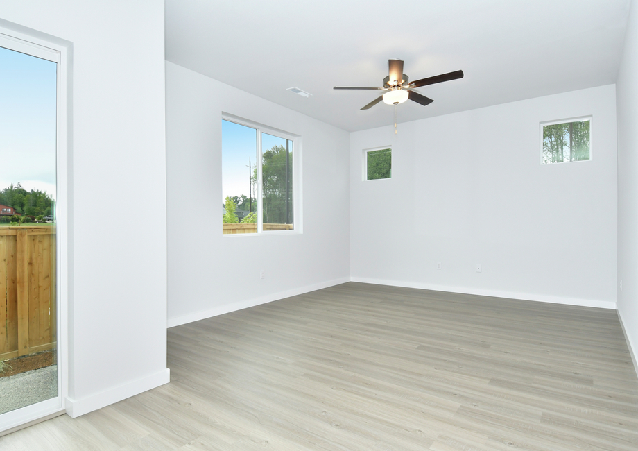 The family room has plank flooring and a ceiling fan.