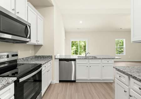 The kitchen boasts beautiful granite countertops and overlooks the living area.