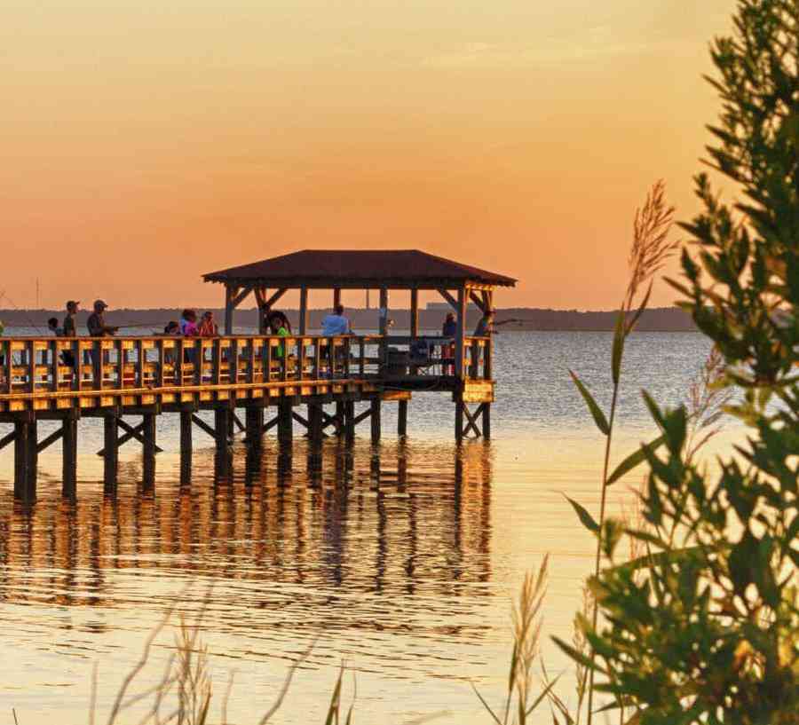 Kure Beach, North Carolina Fort Fisher Air Force Recreation Center at sunset with long wooden pier, water, and plants