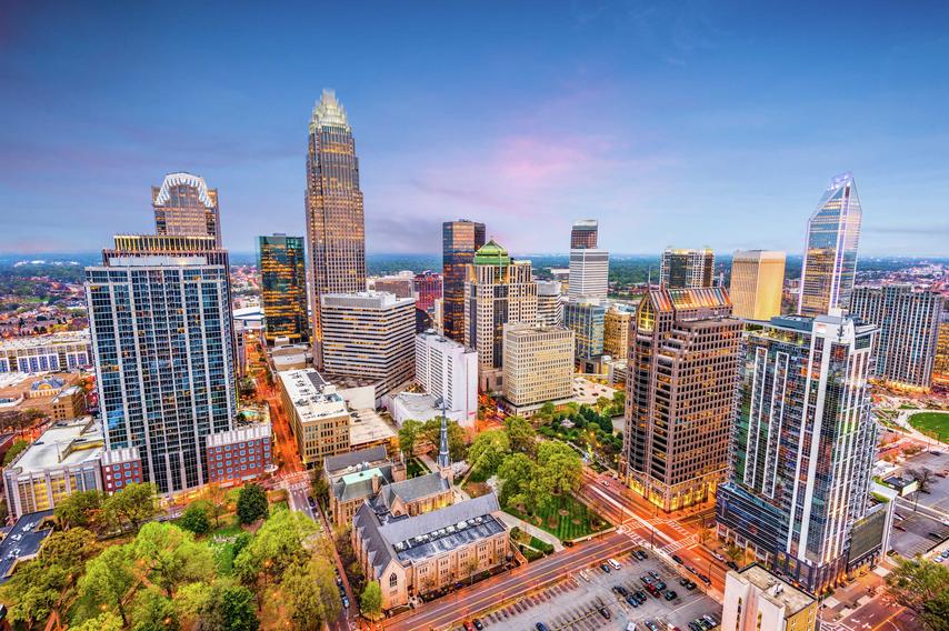 Charlotte, North Carolina downtown buildings showing multiple skyscrapers, green city parks, and blue skies in the distance