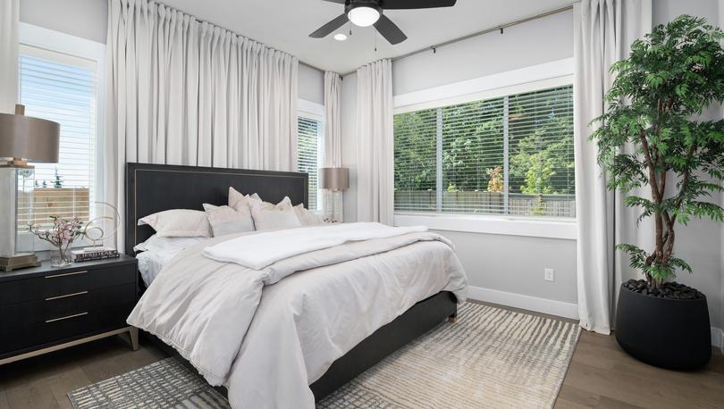 The master bedroom has lots of windows that flood the room with natural light.