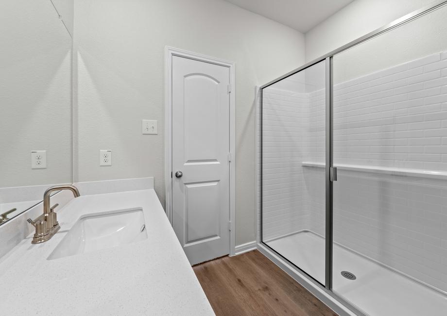 The master bathroom of the Piper has a large vanity space and glass, walk-in shower.