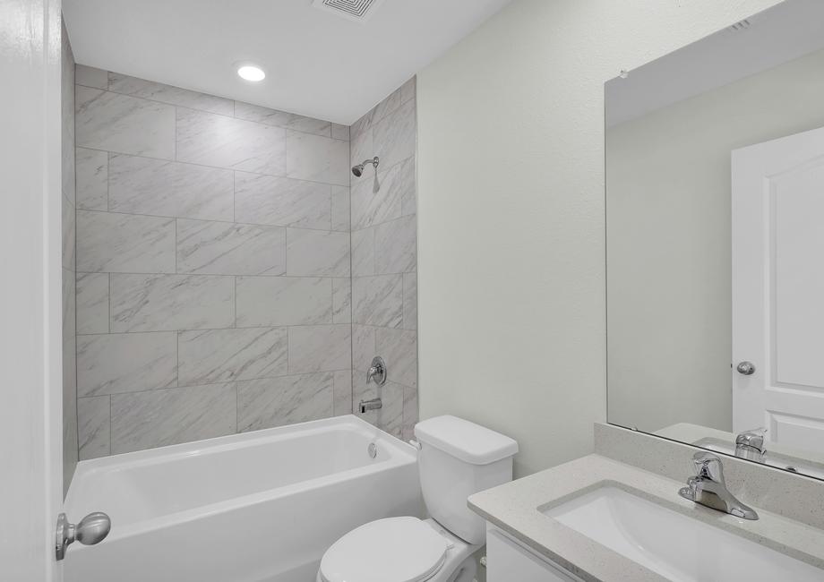The secondary bathroom features a large soaker tub.
