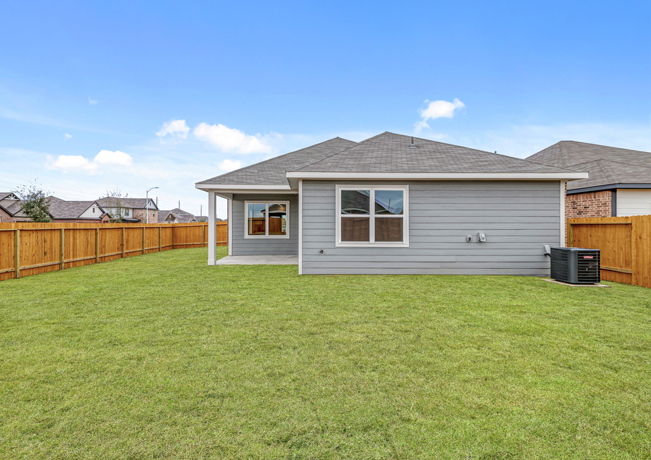 A fully fenced backyard with a covered patio