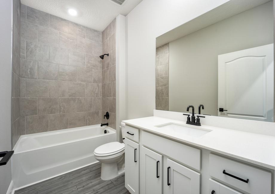 Modern fixtures and details fill the secondary bathroom