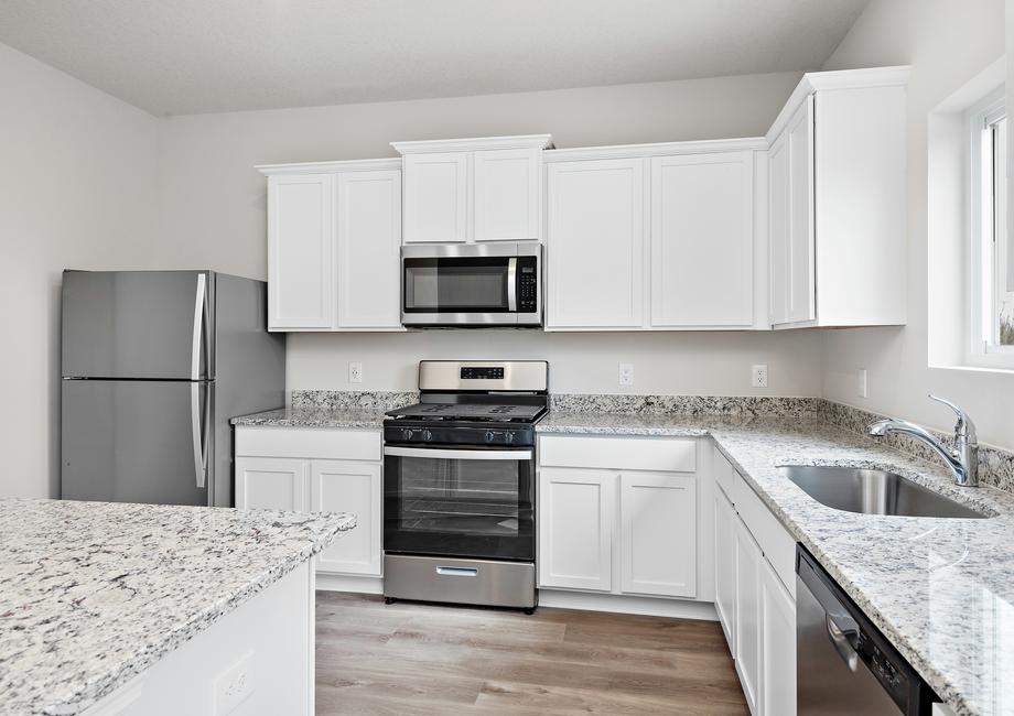 The kitchen has stainless steel appliances and plank flooring.