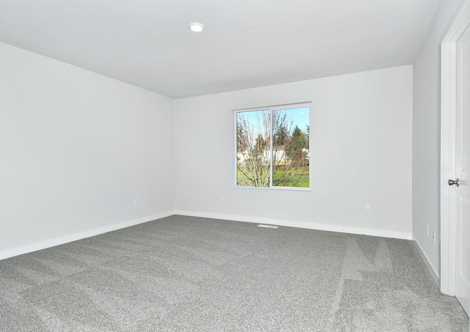 The master bedroom is spacious and has a large window.