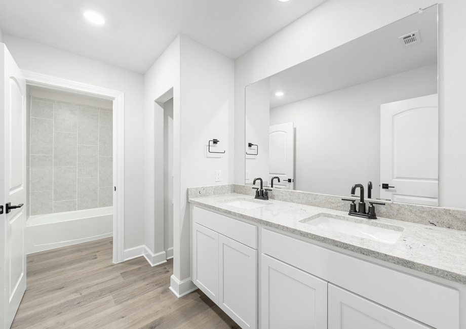 The secondary bathroom of the Driftwood has a large vanity space and shower-tub combo.