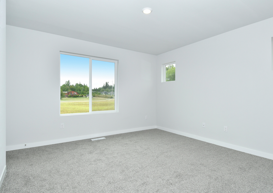 The master bedroom has carpet and a large window.