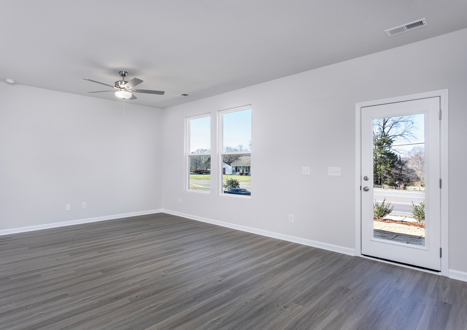 The living room has lots of space and windows that let in lots of natural light