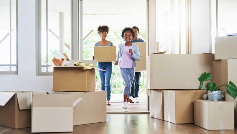 Family carrying boxes into their new home.