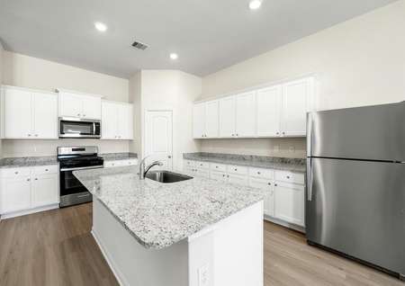The kitchen has stainless steel appliances and plank flooring.