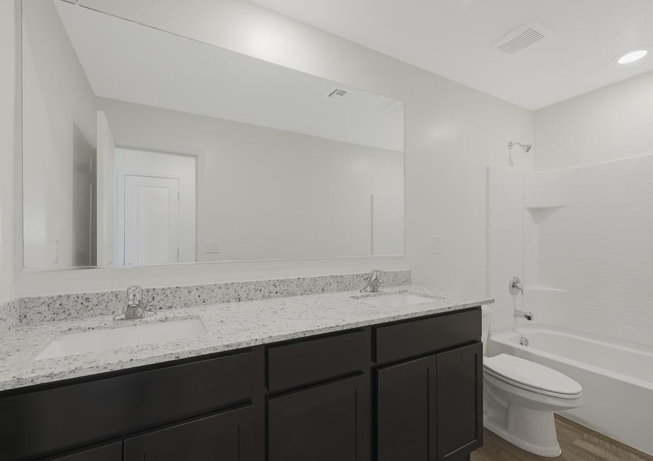 Secondary bathroom with a dual-sink vanity and a dual shower and tub.