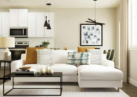 Rendering of living room with a white
  sectional and coffee table. The kitchen can be seen behind the couch.