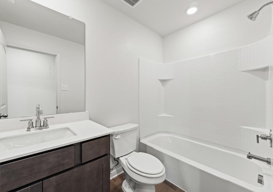 The secondary bathoom has a large vanity space and shower-tub combo.