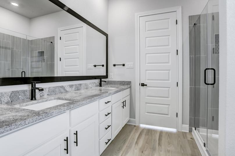 A dual-sink vanity and white cabinetry give the master bath flair.
