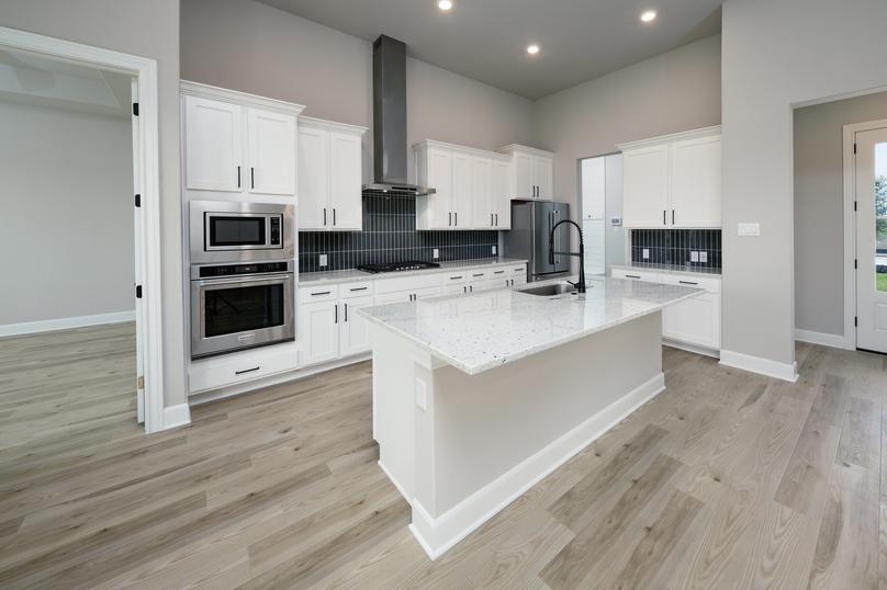 Kitchen with granite island and white cabinets.