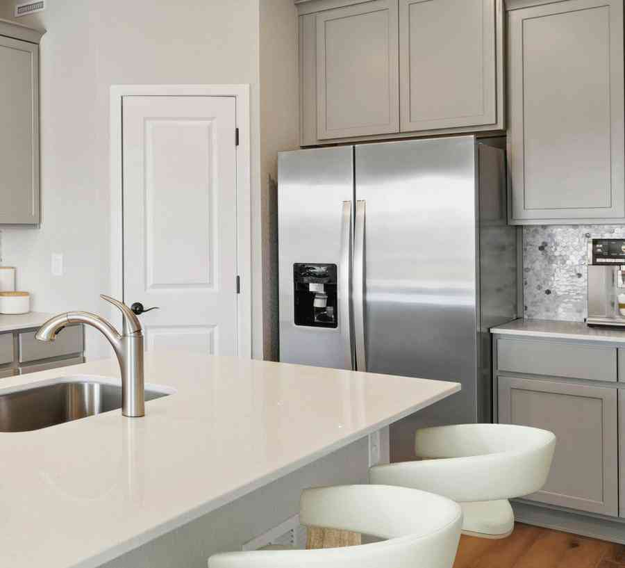 The kitchen has stainless steel appliances and plank flooring.