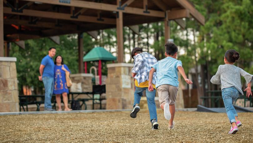 Children running to their parents at the playground.