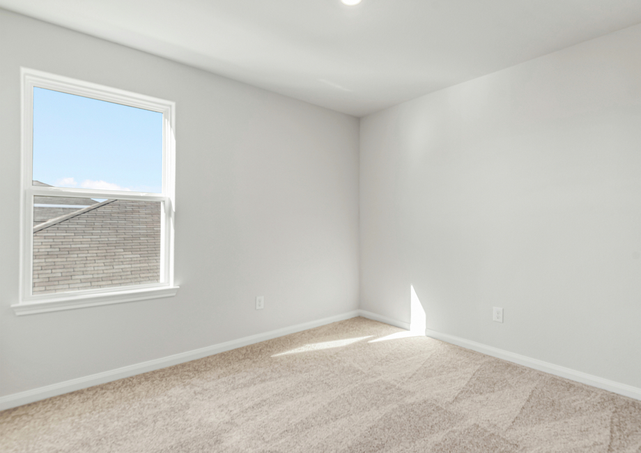 Secondary bedroom with carpet flooring