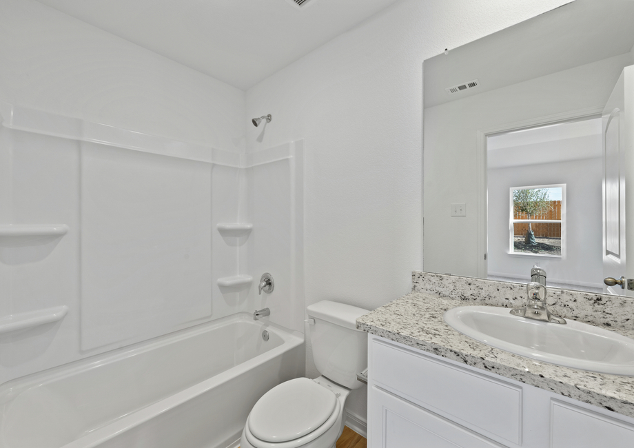 A spacious bathroom with granite countertops