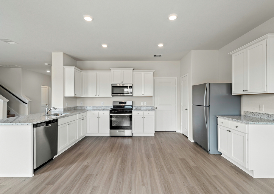 Stainless steel appliances fill the kitchen