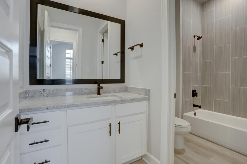 Guest bathroom showcasing a large mirror and white cabinets.