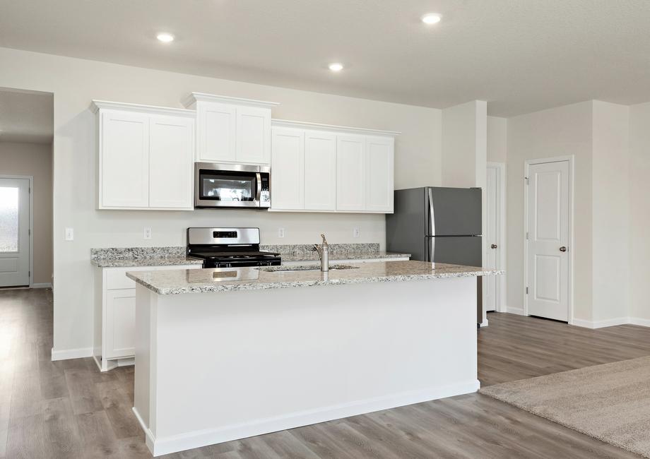 The kitchen has stainless steel appliances and plank flooring.