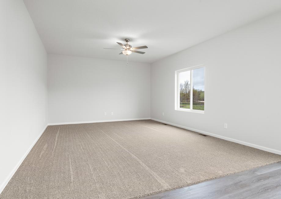 The family room is spacious and has a ceiling fan.