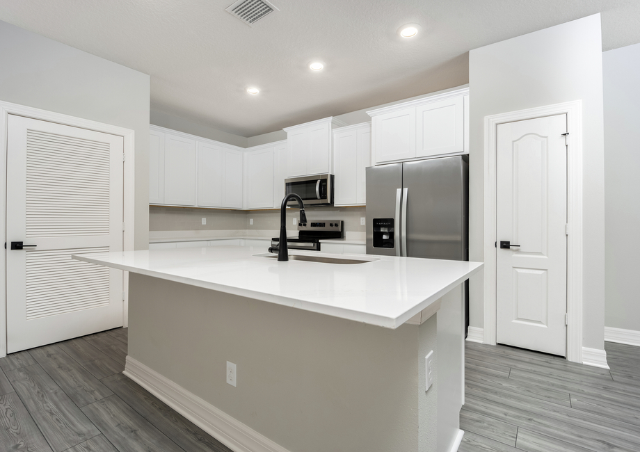 The kitchen island overlooks the dining and family rooms