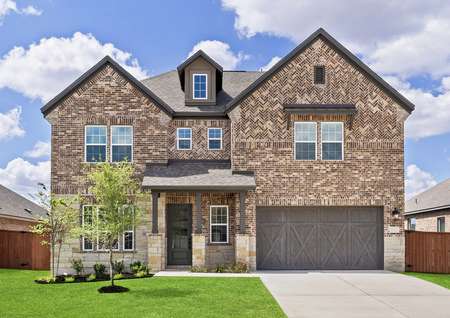 Exterior of the Yale with beautiful landscaping and a two car garage 