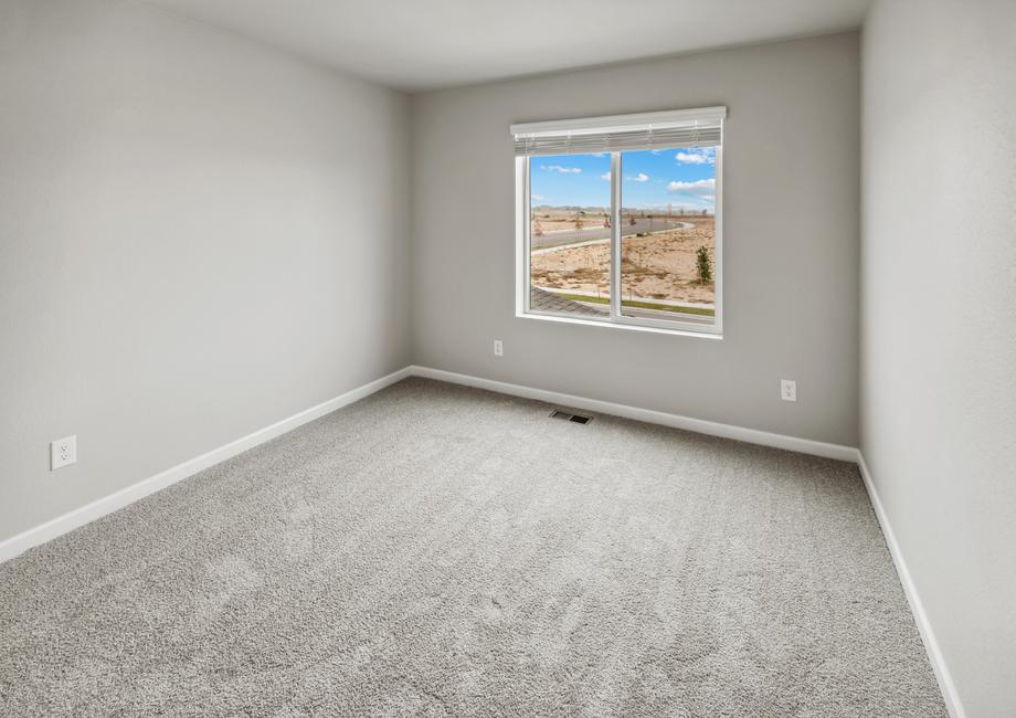 Secondary bedroom with a large window and recessed lighting.