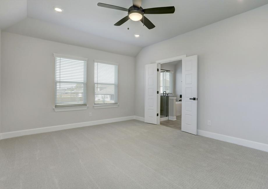 Spacious master bedroom with large windows and a connected bathroom.