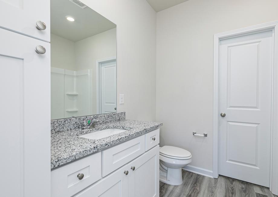 The master bathroom includes plenty of counter and a dual-shower and bathtub