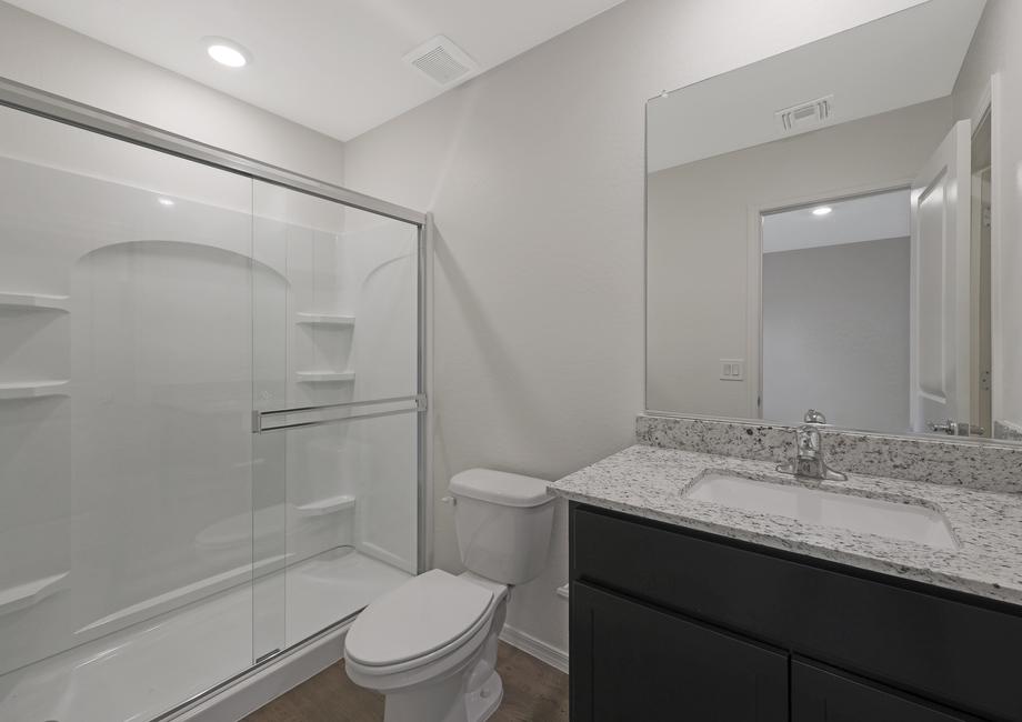 Secondary bathroom with a walk-in shower and single-sink vanity.