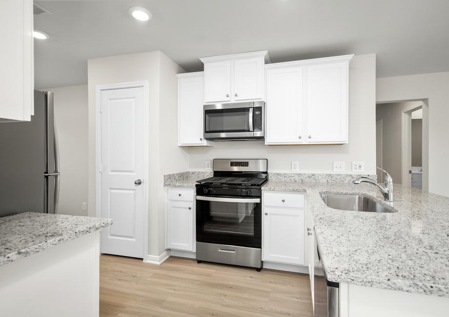 Granite countertops and stainless-steel appliances fill the kitchen.