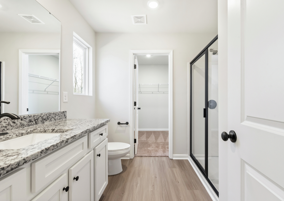 The master bathroom has a glass-enclosed shower.jpg