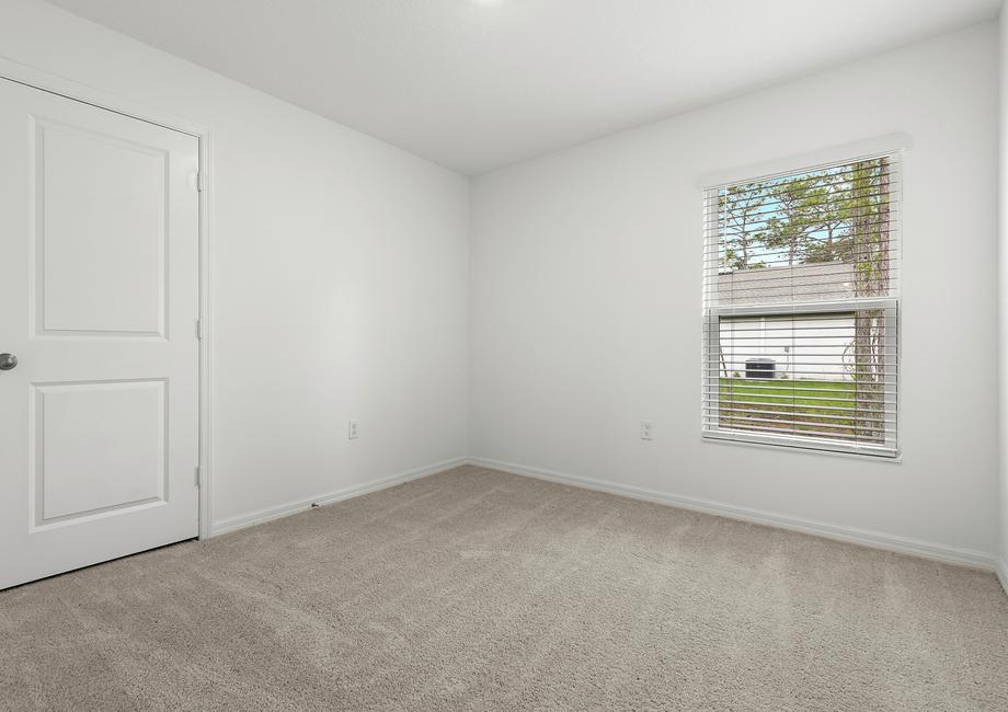 The guest bedroom is spacious with plenty of natural light