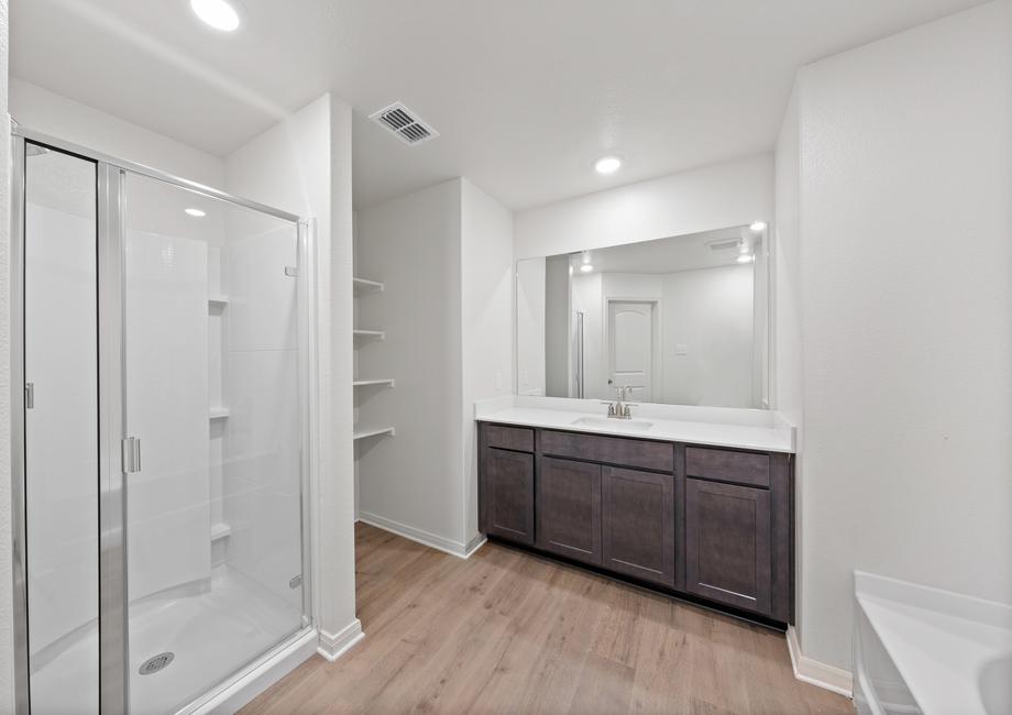 The master bathroom has a large vanity space and glass, walk-in shower.