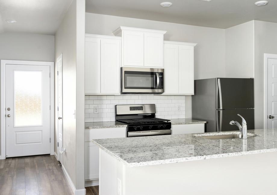 The kitchen of the Coastal has sprawling granite countertops.