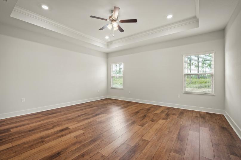 The master bedroom has wood floors, tons of natural light and a ceiling fan.
