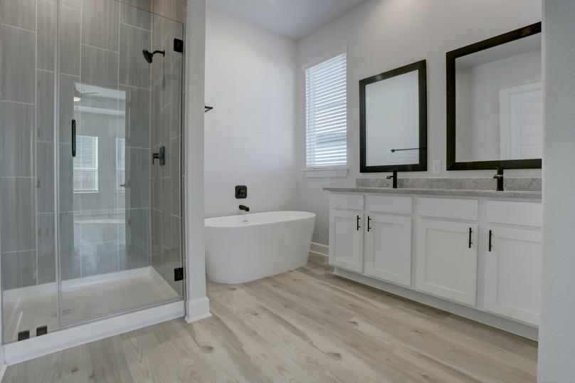 Master bathroom with a soaking tub, walk-in shower, and his and hers sinks.
