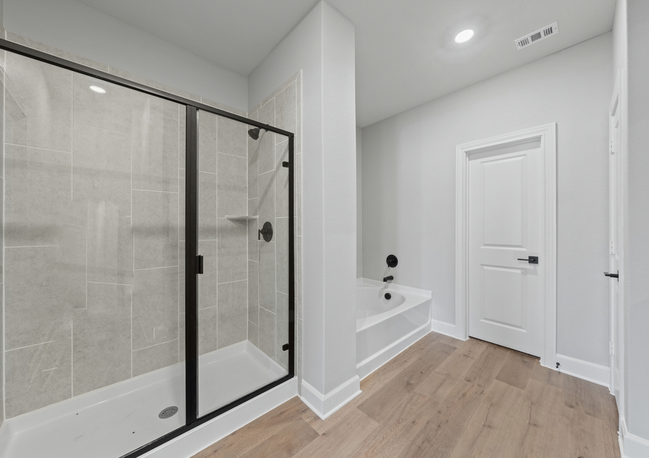The master bathroom has a glass, walk-in shower and a garden tub.