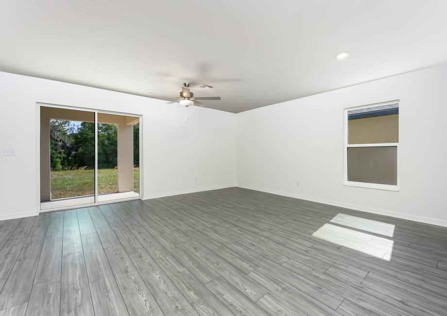 An open-concept dining room and family room with a sliding door to the back patio