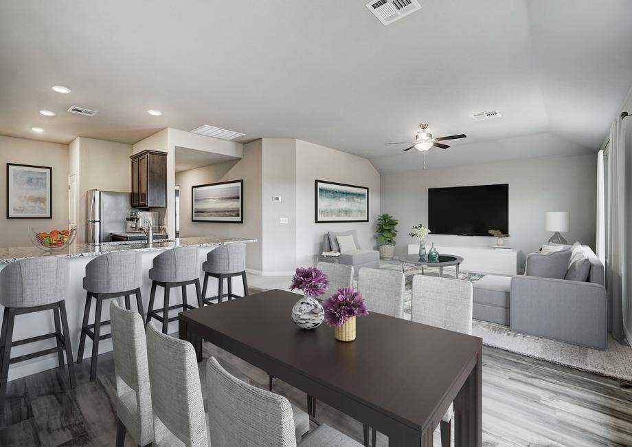 Staged dining room and family room with a brown table and light chairs.